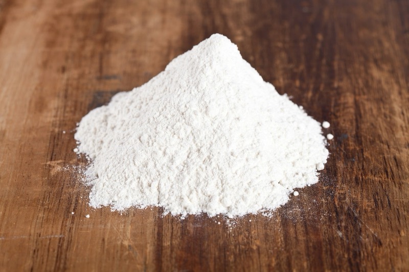 Heap of white powder on a wooden table